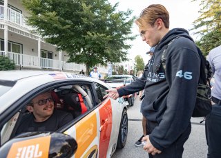 Lucas Weisenberg, driver of the #46 Lucas Racing Toyota GR86 Cup Car, greets fans during the annual parade of cars before Races 9 and 10 at Road America on August 17, 2023. -Photo by Zack Cramer
 | SRO Motorsports Group