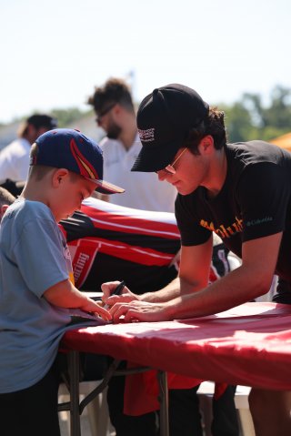 Tyler Wettengel, driver of the #80 Nitro Motorsports Toyota GR86 Cup Car, during an autograph session before Race 10 at Road America on August 20, 2023. -Photo by Dave Biro
 | SRO Motorsports Group