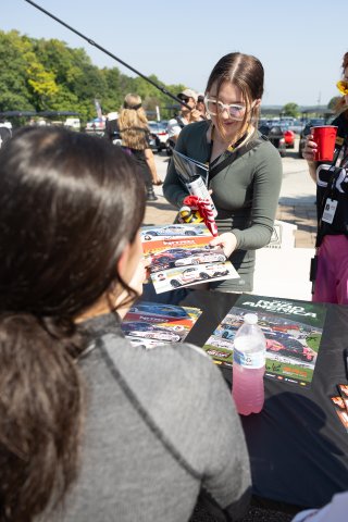 Toni Breidinger, driver of the #70 Nitro Motorsports Toyota GR86 Cup Car, signs autographs before Race 10 at Road America on August 20, 2023. -Photo by Zack Cramer
 | TGRNA               