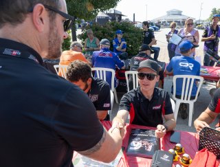 Will Rodgers, driver of the #6 Godwin Motorsports Toyota GR86 Cup Car, signs autographs before Race 10 at Road America on August 20, 2023. -Photo by Zack Cramer
 | TGRNA               