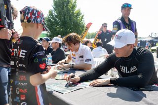 Corey Heim, driver of the #24 Nitro Motorsports Toyota GR86 Cup Car, signs autographs before Race 10 at Road America on August 20, 2023. -Photo by Zack Cramer
 | TGRNA               